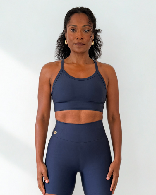 Woman wearing a navy blue athletic outfit on a white background